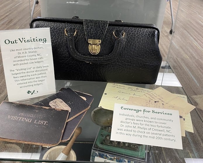 Exhibit shelf featuring Doctor's bag and visitor list.